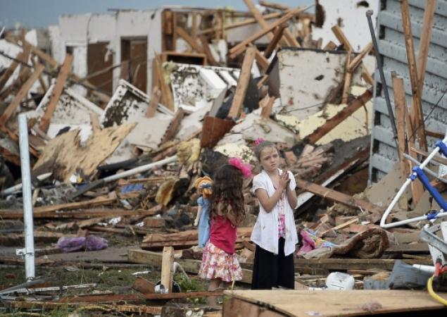 Forlorn children stare at the rubble that was once their house in wake of the tornado.