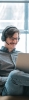 man working on a laptop wearing headphones